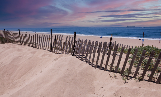 Fence on El Segundo beach at sunset