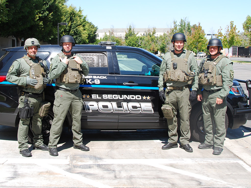 Tactical Paramedics pose in front of police vehicle