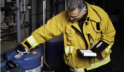 Man in yellow fire jacket inspecting Haz Materials